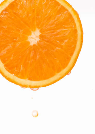 Sliced fresh juicy orange with falling dropsの写真素材