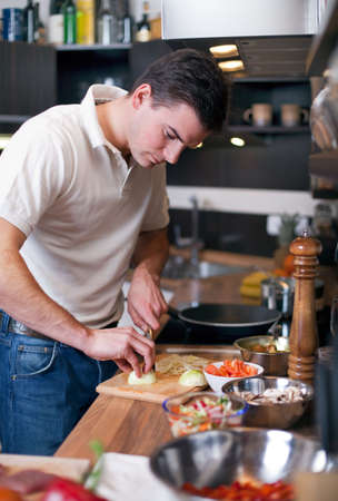 Young handsome man preparing lunch in kitchenの写真素材