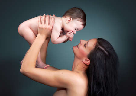 Loving mother holding baby - color studio shotの写真素材