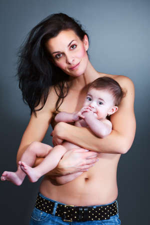 Loving mother holding baby - color studio shot の写真素材