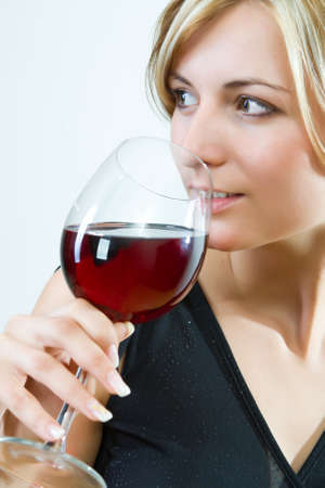 Young woman drinking red wine - white backgroundの写真素材