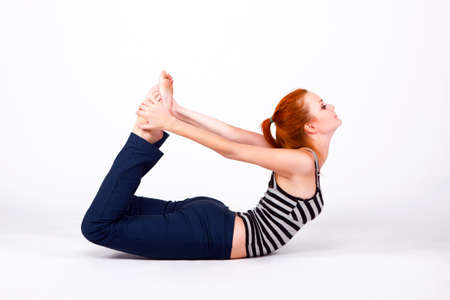 Young woman in back bends pose on whiteの写真素材