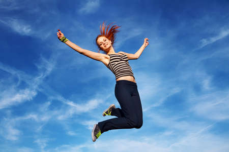 Happy young woman jumping on open air 
