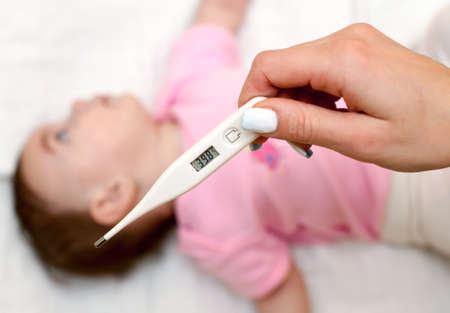 Sick baby being checked for illness and fever.