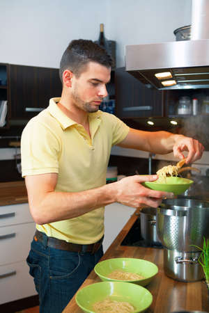 Young handsome man preparing lunch in kitchen の写真素材