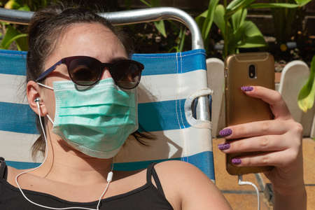 girl sunbathing with glasses and mask in times of pandemic