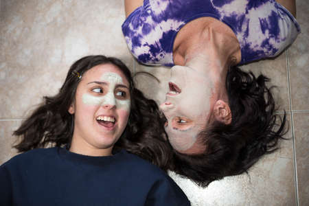 mother and daughter waiting for the beauty treatment to take effect, taking advantage of the...