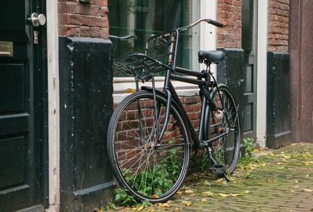 The bicycle is parked next to the house in Amsterdam in Europe. European style of life. A popular, healthy and eco-friendly means of transportation in Holland.の写真素材