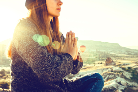 Young beautiful girl practicing yoga at the top of a mountain in Cappadocia at sunrise. Practices of relaxation.の写真素材