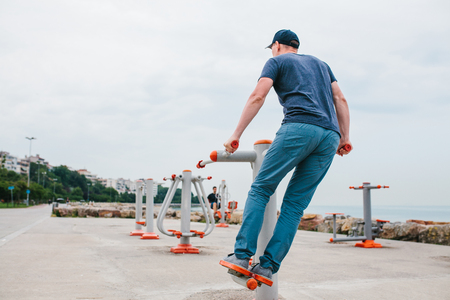 A man trains on sporting equipment in a city in the open air. The concept of a healthy lifestyle and accessibility of sports training for every person. Available sports equipment. Street sports.の写真素材