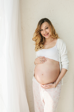 Beautiful adult pregnant woman. Waiting for the baby. Pregnancy. Care, tenderness, motherhood, childbirth.の写真素材