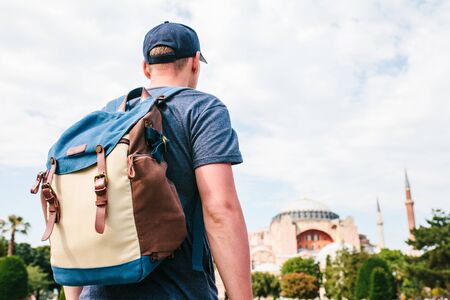 A traveling man with a backpack in Sultanahmet Square near the famous Aya Sofia mosque in Istanbul in Turkey. Travel, tourism, sightseeing.の写真素材