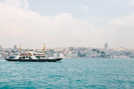 The ship sails along the blue water of the Bosphorus against the backdrop of a beautiful view of the European part of Istanbul. Scenic panoramic view. Travel, rest, vacation.の写真素材