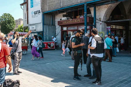 Istanbul, June 15 2017: People at Eminonu Square in the middle of the day - police officers, man talking on the phone and random passerby.のeditorial素材