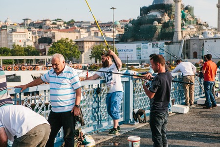 Istanbul, June 15, 2017: Many fishermen from the local population stand on the Galata bridge and fish. The traditional hobby of the inhabitants of Istanbul.のeditorial素材