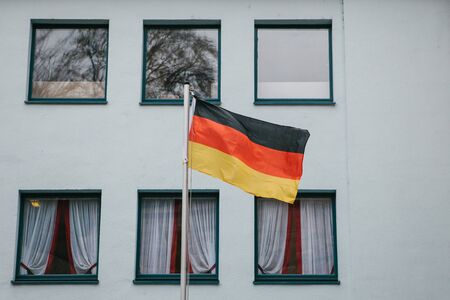 German flag on the outside of the building next to the windows. Patriotic sentiments before the elections.の写真素材