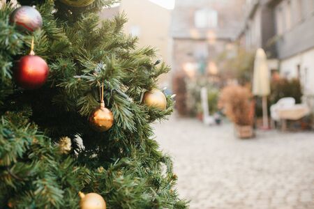 Christmas decorations on a Christmas tree in the form of red and gold balls. Christmas tree on a street in an european city. Outdoors. The concept of a holiday.の写真素材