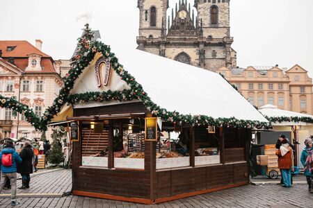 Prague, December 13, 2016: Old Town Square on Christmas Day. Christmas market in the main square of the city. Decoration tent with various sweets and national food. Tourists are walking nearby.のeditorial素材