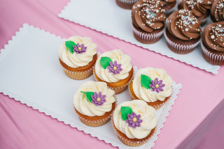 Freshly baked vanilla cupcakes with butter cream, top view.の写真素材