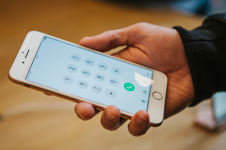 The day of the presentation of the iPhone 8 and iPhone 8 plus and the sale of new Apple products in the official Apple store in Berlin. The buyer holds the new iPhone 8 Plus in its hands and looks at its characteristics and mobile applications.のeditorial素材