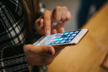 The day of the presentation of the iPhone 8 and iPhone 8 plus and the sale of new Apple products in the official Apple store in Berlin. The buyer holds the new iPhone 8 Plus in its hands and looks at its characteristics and mobile applications.のeditorial素材
