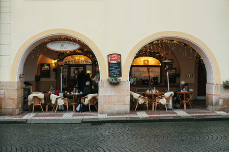 Prague, December 25, 2016: Cozy cafe on the street - with tables, wicker chairs and sheep rugs with Christmas decorのeditorial素材
