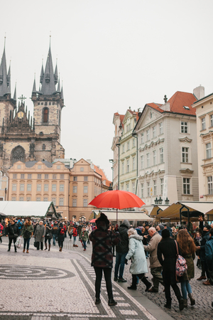 Prague, December 13, 2016: A guide with a traditional red umbrella on the Old Town Square in Prague invites tourists to visit the sights. Tourism in Christmas. Czech Republic. Europe.のeditorial素材