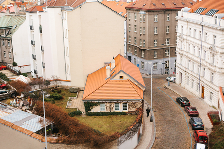 View from a high point. A beautiful view from above on the streets, roads and roofs of houses in Prague. Traditional ancient urban architecture. The road, the car is parked, ordinary life.の写真素材