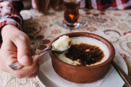 A girl in a cafe with a spoon has a baked rice dessert.の写真素材