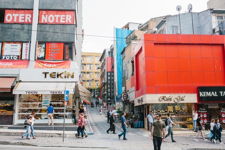 Crowd of people walk down the street on the background of building with lot of shops and cafeのeditorial素材