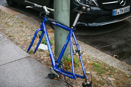 Berlin, October 2, 2017: Blue bicycle attached to street pillar with lock stands without wheels after being stolen in the German capitalのeditorial素材