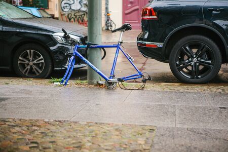 Berlin, October 2, 2017: Blue bicycle attached to street pillar with lock stands without wheels after being stolen in the German capitalのeditorial素材