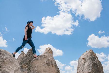 Young beautiful travel girl on top of a hill in Cappadocia, Turkey. Travel, success, freedom, achievement. She goes.の写真素材