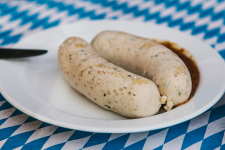 Traditional Bavarian sausages on a plate with sauce. Celebrating the traditional German beer festival called Oktoberfestの写真素材