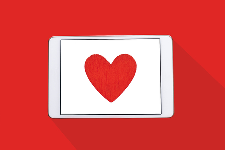 Top view. Red heart on the tablet screen.の写真素材