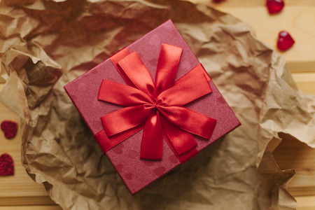 A gift in a beautiful crane box tied with a ribbon on a wooden surface.の写真素材