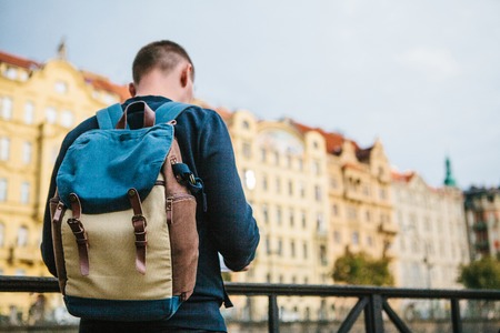 A tourist with a backpack in front of a beautiful old architecture in Prague in the Czech Republic. He looks at the map.の写真素材