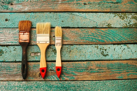 Old brush and two new brushes on a wooden surface. Business concept teamwork, team building.の写真素材