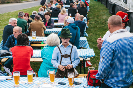 Prague, September 23, 2017: Celebrating the traditional German beer festival Oktoberfest in the Czech Republic. The father communicates with the friend the son stands nearby. Nearby a lot of beer.のeditorial素材