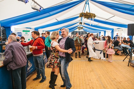Prague, September 23, 2017: Celebrating the traditional German beer festival called Oktoberfest. A man and a woman are dancing, having fun and fooling around at a party.のeditorial素材