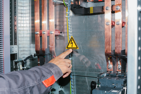 Electrician specialist checking low-voltage cabinet equipmentの写真素材