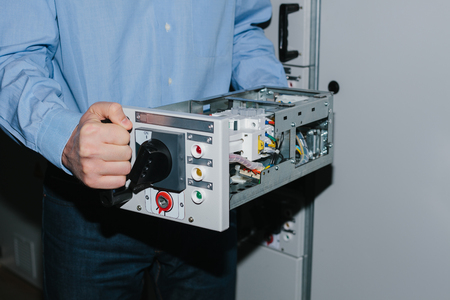 Electrician specialist checking low-voltage cabinet equipmentの写真素材