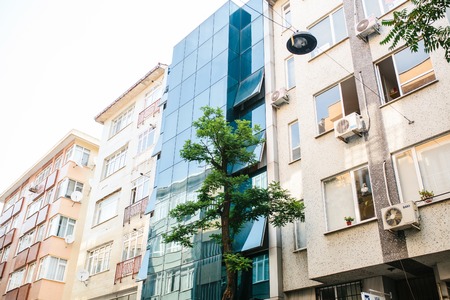 Istanbul, June 15, 2017: Exterior of a new modern glass design hotel between old traditional buildings. Modern architecture next to the old typical architecture. Diversity of buildings.のeditorial素材
