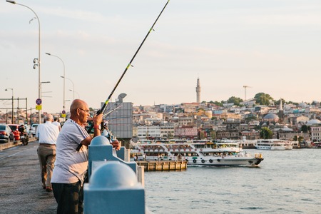 Istanbul, June 15, 2017: A fisherman from the local population stands on the Galata bridge and fishes. Traditional hobby of the inhabitants of Istanbul.のeditorial素材