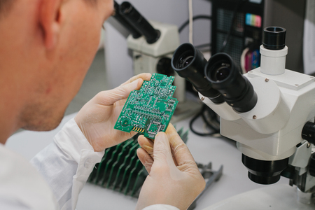 Computer expert professional technician examining board computer in a laboratory in a factory....