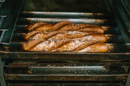 A lot of ready-made fresh bread in a bakery oven in a bakery. Bread making business.