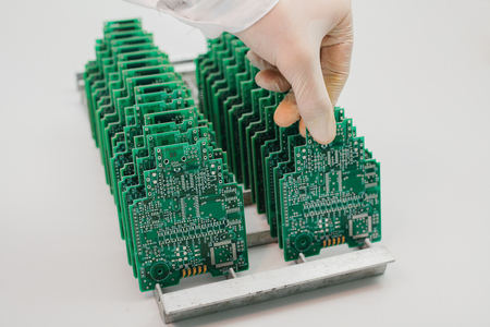 The technician takes a computer board with chips. Spare parts and components for computer equipment. Production of electronics and maintenance. The concept of high technology.の写真素材