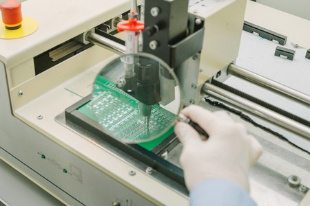 Automation of machine assembly of computer circuit board in the factory for the production of computer components. The process of soldering the board. Factory for the production of microchips.の写真素材