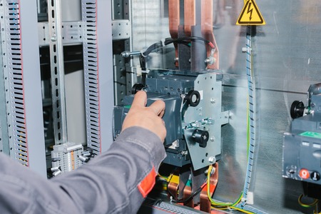 Electrician specialist checking low-voltage cabinet equipment