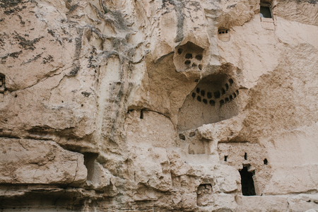 Holes in the mountains of Cappadocia in the form of windows. Inside the mountains is the habitation of ancient people who lived many millions of years ago. Now its empty.の写真素材